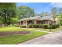 Brick home featuring black shutters, manicured bushes, and a sidewalk leading to the inviting yellow front door at 658 Hiawatha Pl, Burlington, NC 27217
