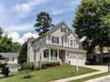 Inviting two-story home with a charming front porch and a well-maintained lawn at 8001 Strawberry Meadows St, Raleigh, NC 27613