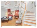 Open-concept living room featuring hardwood floors, a staircase, and a view into the dining area at 805 N Columbia St, Chapel Hill, NC 27516