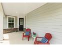 Inviting front porch features cozy red chairs, brick accents, and a stylish black front door at 8217 White Star Dr, Fuquay Varina, NC 27526