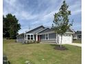 Attractive one-story home with gray siding, stone accents, a red front door, and a well-manicured lawn at 8680 Kenridge Ln, Fuquay Varina, NC 27526