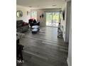A cozy living room featuring wood floors, a sliding glass door to the backyard, and modern furniture at 8680 Kenridge Ln, Fuquay Varina, NC 27526