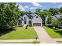 Charming two-story home with landscaped yard, a two-car garage, and beautiful architectural details at 8828 Deerland Grove Dr, Raleigh, NC 27615