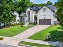 Charming two-story home with landscaped yard, a two-car garage, and beautiful architectural details at 8828 Deerland Grove Dr, Raleigh, NC 27615
