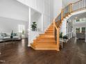Spacious foyer featuring a grand staircase, hardwood floors, and abundant natural light at 8828 Deerland Grove Dr, Raleigh, NC 27615
