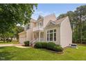 Beautiful home exterior with manicured lawn, complementing shrubbery and a two-car garage at 9728 Batesville Dr, Raleigh, NC 27617