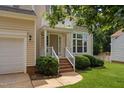 Inviting home entrance with brick steps, white railings, and manicured landscaping at 9728 Batesville Dr, Raleigh, NC 27617