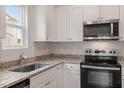 Bright kitchen showcasing granite countertops, stainless appliances, and ample white cabinetry at 100 Flue Ct, Oxford, NC 27565