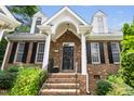 Inviting brick front entrance with black door and decorative columns at 1003 Blackberry Ln, Durham, NC 27712