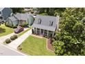 Aerial view of a home featuring a manicured lawn, driveway, covered porch and dormer windows at 1033 Mills St, Raleigh, NC 27608