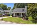 Lovely home with a manicured lawn, covered porch, dormer windows, and beautiful landscaping at 1033 Mills St, Raleigh, NC 27608