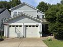 Traditional two-story home featuring a two-car garage, light blue siding, well-maintained yard, and mature trees at 10415 Neland, Raleigh, NC 27614