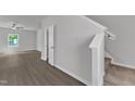 Bright living room with sleek wood-look floors, a ceiling fan, and a staircase leading to the second floor at 106 Flue Ct, Oxford, NC 27565