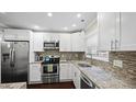 Bright kitchen features granite counters, stainless steel appliances and mosaic backsplash at 11 Willow Bridge Dr, Durham, NC 27707