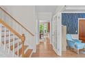 Hallway with hardwood floors, staircase, and doorway leading to the adjacent office and kitchen at 113 Chestone Ct, Cary, NC 27513