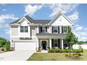 Charming two-story home featuring a welcoming front porch and manicured landscaping at 124 Airlie Place Ln, Willow Springs, NC 27592