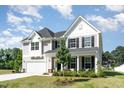 Charming two-story home featuring a welcoming front porch and manicured landscaping at 124 Airlie Place Ln, Willow Springs, NC 27592