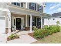 Inviting home entrance featuring a covered front porch with columns and stylish landscaping at 124 Airlie Place Ln, Willow Springs, NC 27592