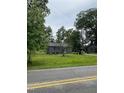 Charming gray house nestled among mature trees with a green lawn at 12600 Old Stage Rd, Willow Springs, NC 27592
