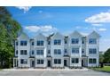 View of townhomes featuring white siding, black windows, and well-manicured landscaping at 1532 Crescent Townes Way, Raleigh, NC 27604