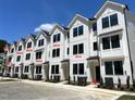 Multiple townhouses feature crisp white siding, dark-trimmed windows, and professionally landscaped yards at 1532 Crescent Townes Way, Raleigh, NC 27604