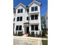 A modern townhouse features white siding, black windows, and neatly arranged landscaping at 1532 Crescent Townes Way, Raleigh, NC 27604