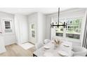Bright dining room with modern chandelier and views of the landscaped backyard at 1537 Piney Fls Dr, Wendell, NC 27591