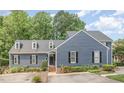 Beautiful blue home with black shutters and manicured landscaping at 1547 Village Glenn Dr, Raleigh, NC 27612