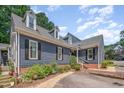 Charming exterior featuring a landscaped yard, blue siding, and dormer windows at 1547 Village Glenn Dr, Raleigh, NC 27612