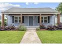 Charming blue home featuring a cozy front porch with lovely landscaping and inviting curb appeal at 208 Maywood Ave, Raleigh, NC 27603