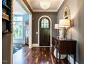Welcoming foyer featuring hardwood floors, elegant lighting, and a glimpse of the dining room at 2125 Pine Dr, Raleigh, NC 27608