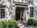 Close up of the front door, framed by manicured shrubbery and a stylish portico at 2125 Pine Dr, Raleigh, NC 27608