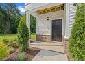 Inviting entryway with black front door, brick accents, and well-maintained landscaping at 223 Faith Avenue, Sanford, NC 27330