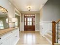 Elegant entryway featuring a hardwood floor, wainscoting, and a stylish light fixture at 3021 Lawson Walk Way, Rolesville, NC 27571
