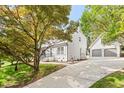 Beautiful exterior view showcasing the home, detached two-car garage, long driveway, and mature trees at 3129 Merrianne Dr, Raleigh, NC 27607