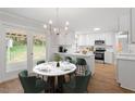 Bright eat-in kitchen features white cabinetry, stainless appliances, and a door to the backyard at 3129 Merrianne Dr, Raleigh, NC 27607