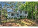 Beautiful light blue split-level home with white shutters surrounded by lush greenery and mature trees at 320 Bainbridge Cir, Garner, NC 27529