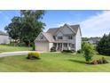 Beautiful two-story home featuring a lush green lawn and mature landscaping at 3525 Daisy Ln, Wake Forest, NC 27587