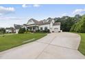 Inviting exterior of a white home with lush green lawn and a long driveway leading to the garage at 3829 Sleepy Brook Ln, Apex, NC 27539