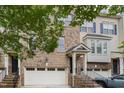 Close-up of brick townhome with attached garage and front entryway with stairs at 404 Panorama Park Pl, Cary, NC 27519