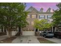 Charming townhome exterior featuring a brick facade, attached garages, and well-maintained landscaping at 404 Panorama Park Pl, Cary, NC 27519