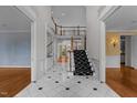 Grand foyer featuring elegant black and white tile flooring, staircase, and open floor plan at 4315 Sugar Pine Ln, Durham, NC 27705