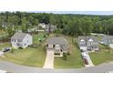 An aerial view shows a two-story home situated in a well-maintained neighborhood with green lawns and mature trees at 433 Village Bend Dr, Fuquay Varina, NC 27526