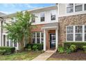 Charming townhome featuring a blend of brick and stone facade with manicured landscaping at 4826 Sir Duncan Way, Raleigh, NC 27612