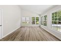 Bright sunroom features cathedral ceilings, many windows, and beautiful laminate flooring throughout at 5317 Peacenest Dr, Raleigh, NC 27610