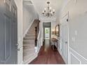 Inviting foyer featuring hardwood floors, a staircase, and a chandelier that offers a warm welcome at 5505 Heather Garden Way, Raleigh, NC 27613