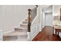 Carpeted staircase with wooden handrail and white trim, leading to the upper level of the home at 5505 Heather Garden Way, Raleigh, NC 27613