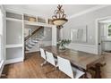 Bright dining room featuring hardwood floors, stylish chandelier, and access to the staircase at 5809 N Hawthorne Way, Raleigh, NC 27603