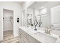 Bright bathroom featuring double sinks, grey cabinets, large mirror and modern fixtures at 760 Deschutes Dr, Garner, NC 27529