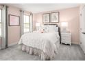 Bright bedroom featuring a luxurious bed with a white comforter, soft pink walls, and lots of natural light at 816 Walker Ridge Way, Willow Springs, NC 27592